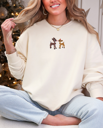Cream crewneck with Rudolph the Red-Nosed Reindeer and Clarice embroidered on it.