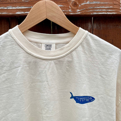Ivory Comfort Colors tee with small navy fish on front left chest