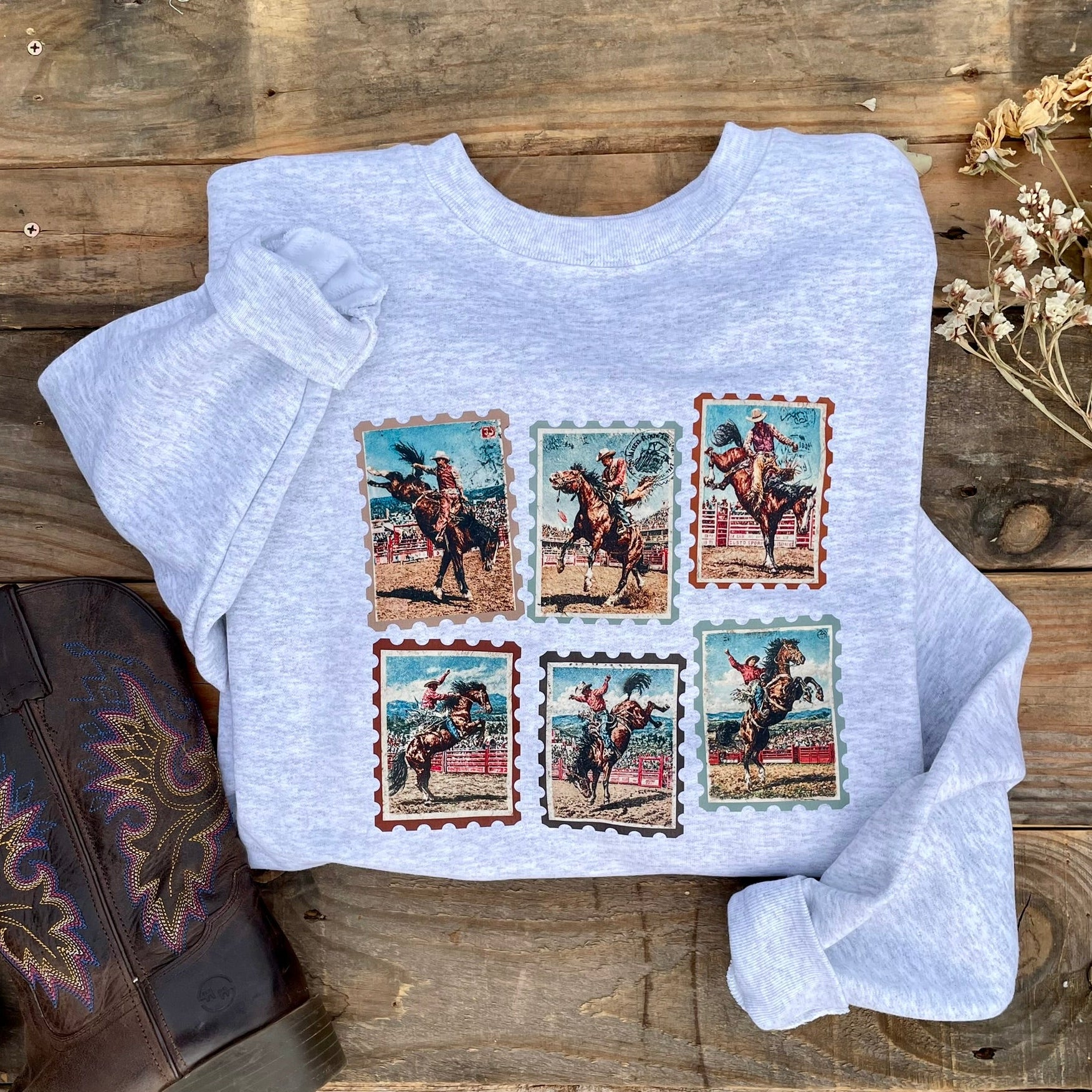 Heather gray crewneck sweathshirt with vintage bronc riding stamps on it